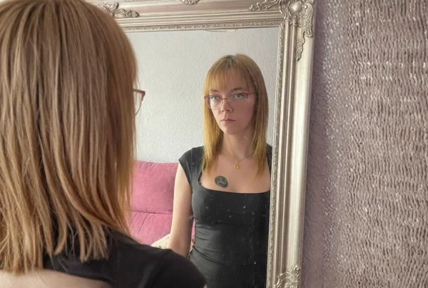 Mujer frente a un espejo representando la reconstrucción de la identidad, los límites emocionales y el autoconocimiento en el trabajo sexual