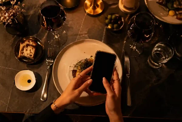 Sugar baby en cita de sugar dating en restaurante elegante en España revisando el móvil