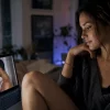 Mujer viendo contenido gay masculino en un portátil como representación del deseo femenino y la mirada femenina